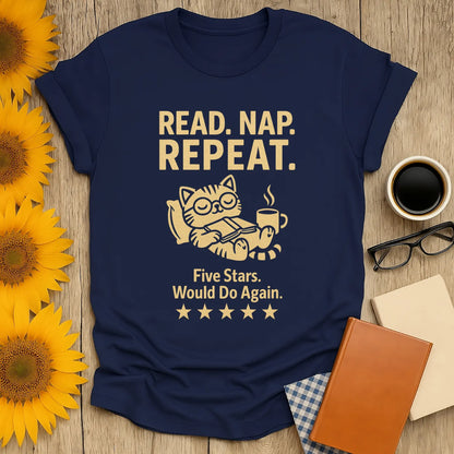 Cozy navy tee with a cat reading a book and coffee, saying 'Read. Nap. Repeat.' Perfect gift for book lovers.