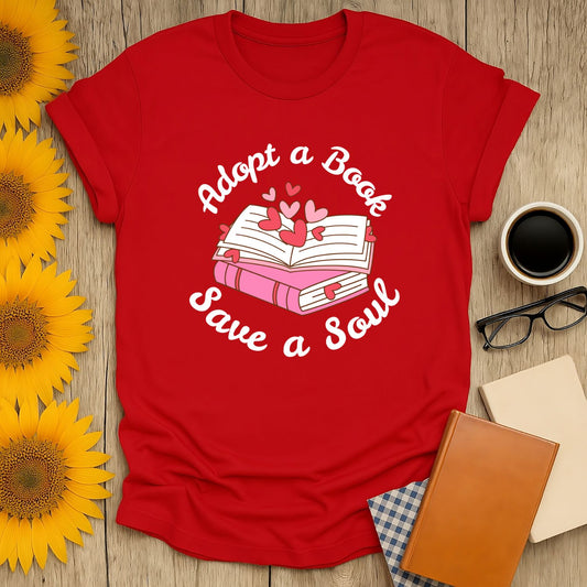 Red t-shirt with 'Adopt a Book, Save a Soul' graphic for book lovers, surrounded by sunflowers and coffee.