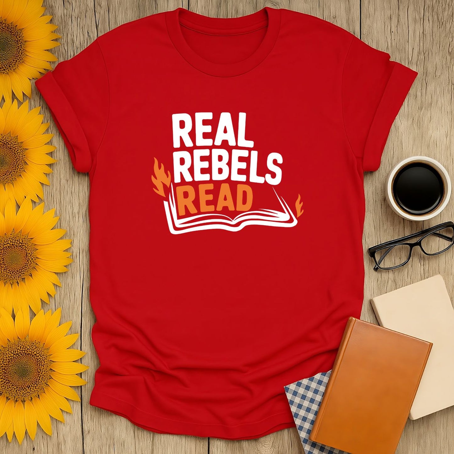Bright red t-shirt with 'Real Rebels Read' text over an open book illustration, perfect gift for book lovers and readers.