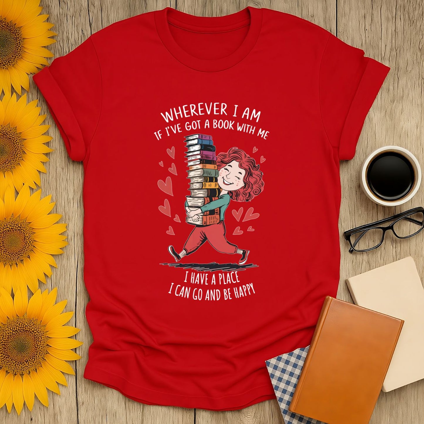 Book lover shirt featuring a joyful reader with stacked books, saying "Wherever I am, if I've got a book with me, I have a place I can go and be happy!"