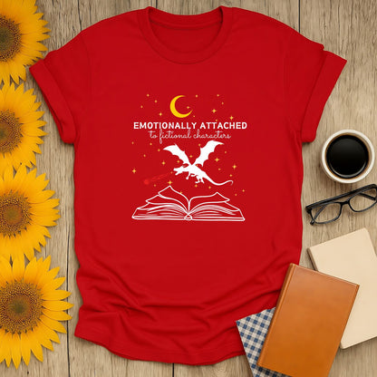 Red literary tee featuring a whimsical dragon atop an open book with the text 'Emotionally Attached to Fictional Characters,' perfect for cozy book lovers.