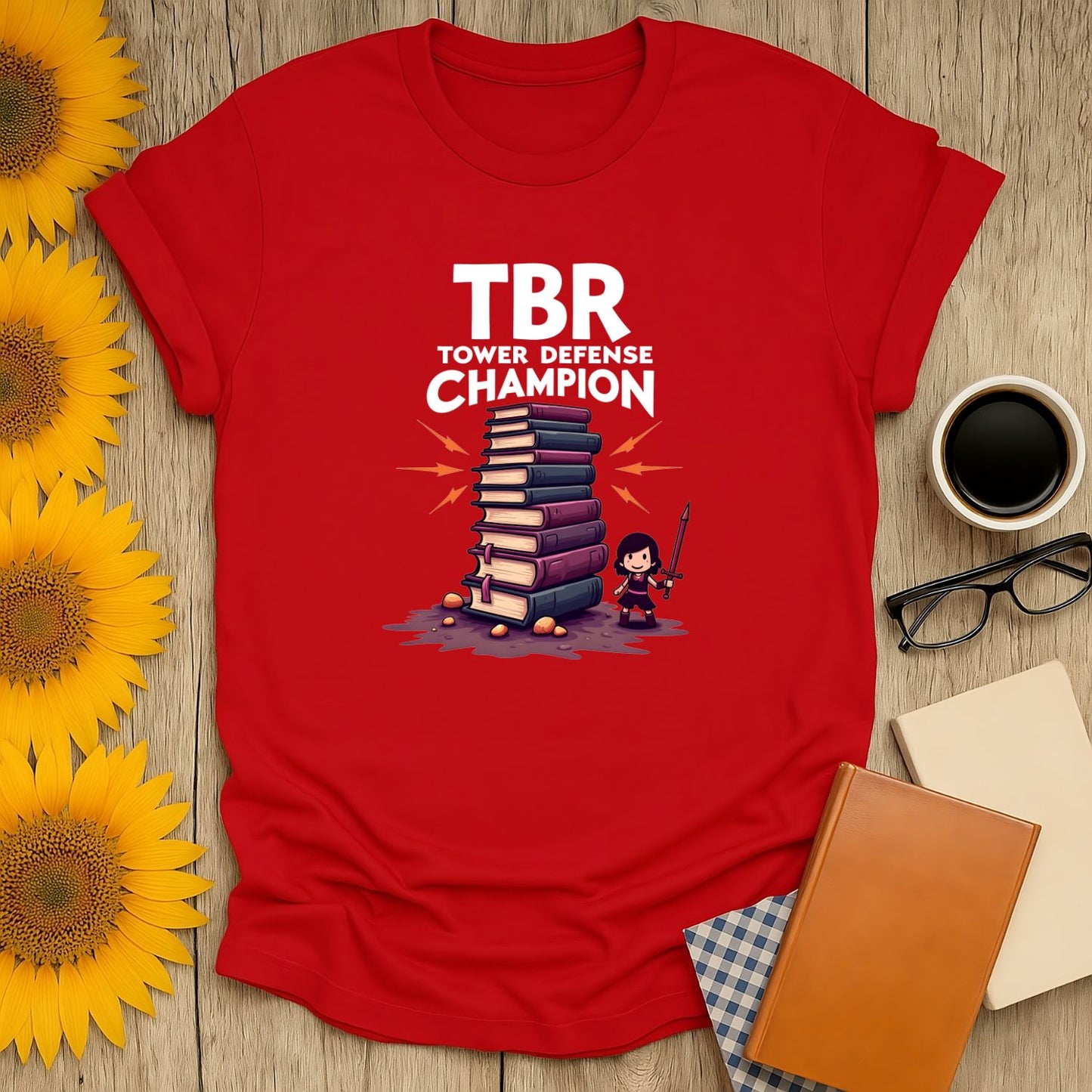 TBR Defender T-Shirt for book lovers featuring a graphic of a tower of books and a character, perfect for reading enthusiasts.
