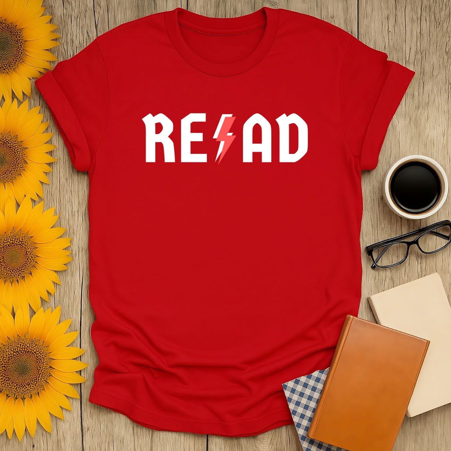 Bright red t-shirt with 'READ' in bold white letters featuring a lightning bolt, perfect for cozy moments with books and coffee.