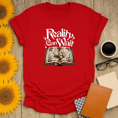 Reality Can Wait T-Shirt featuring a whimsical open book, perfect for book lovers, cat enthusiasts, and cozy readers.