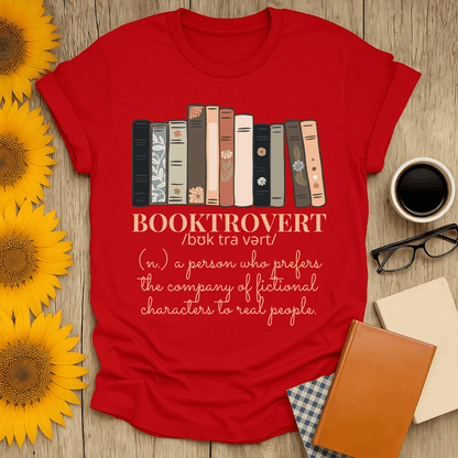 Booktrovert t-shirt in red, featuring a fun definition for book lovers, surrounded by sunflowers and books.