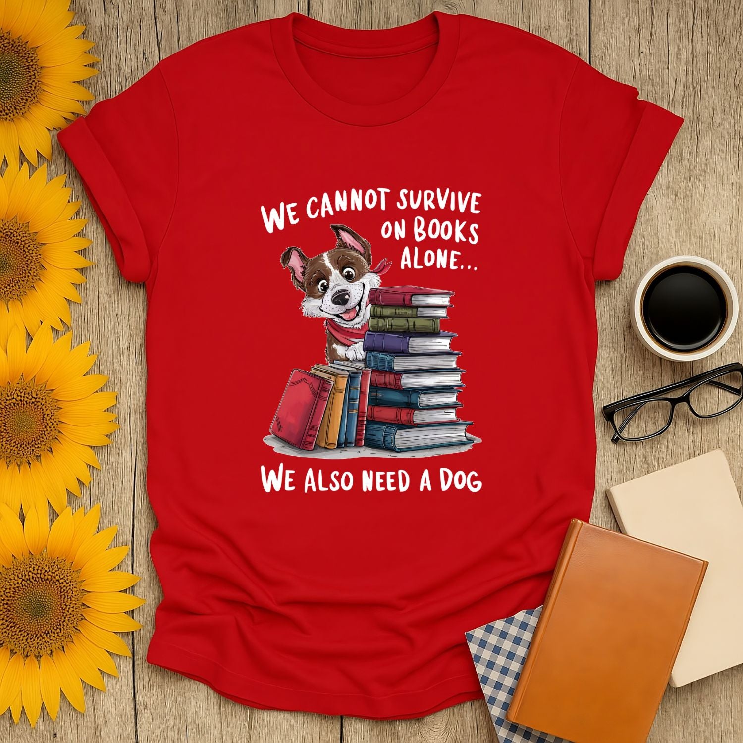 Funny book lover shirt with a cute dog, stacks of books, and text saying "We cannot survive on books alone..." Perfect for cozy readers!