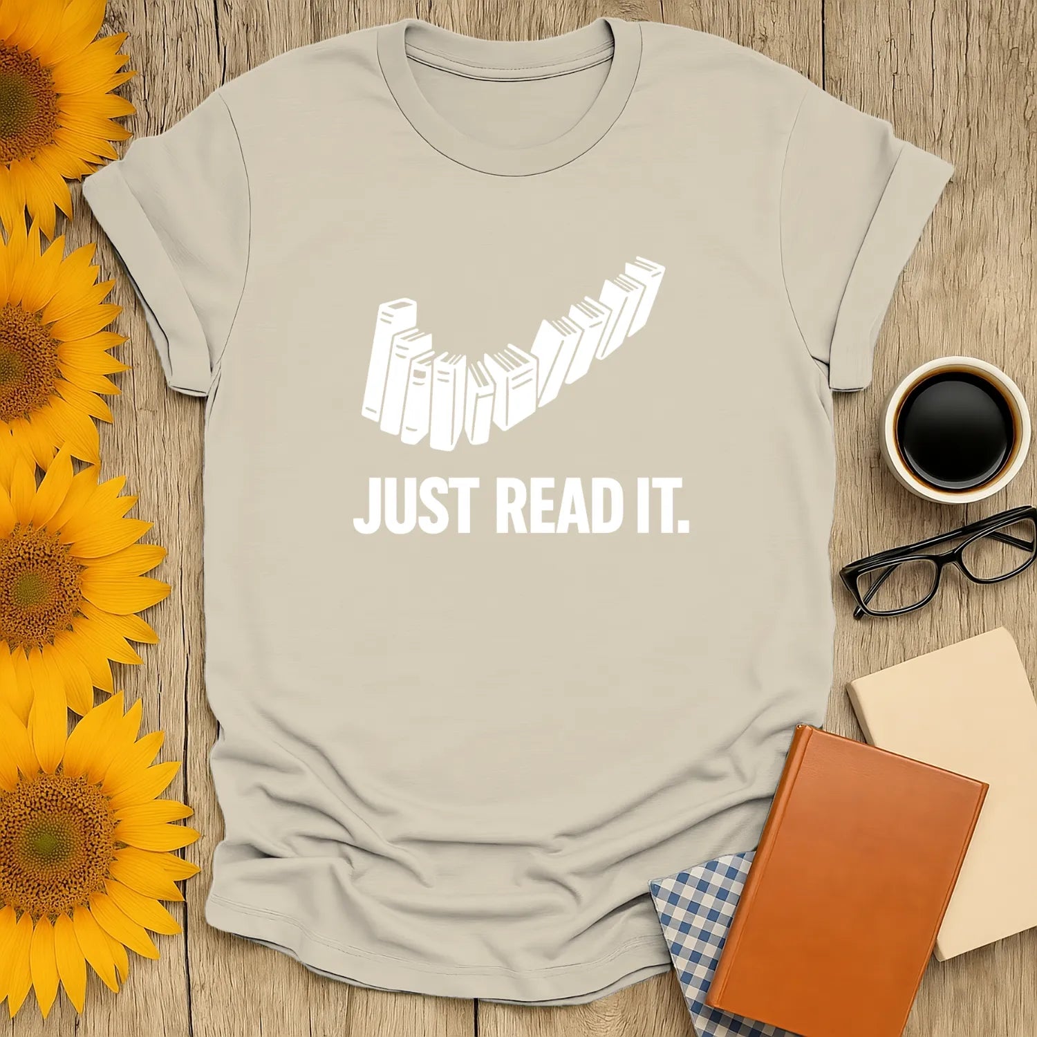 A cozy beige t-shirt with stacked books and the phrase 'JUST READ IT.' Perfect for book lovers and gifts for readers.