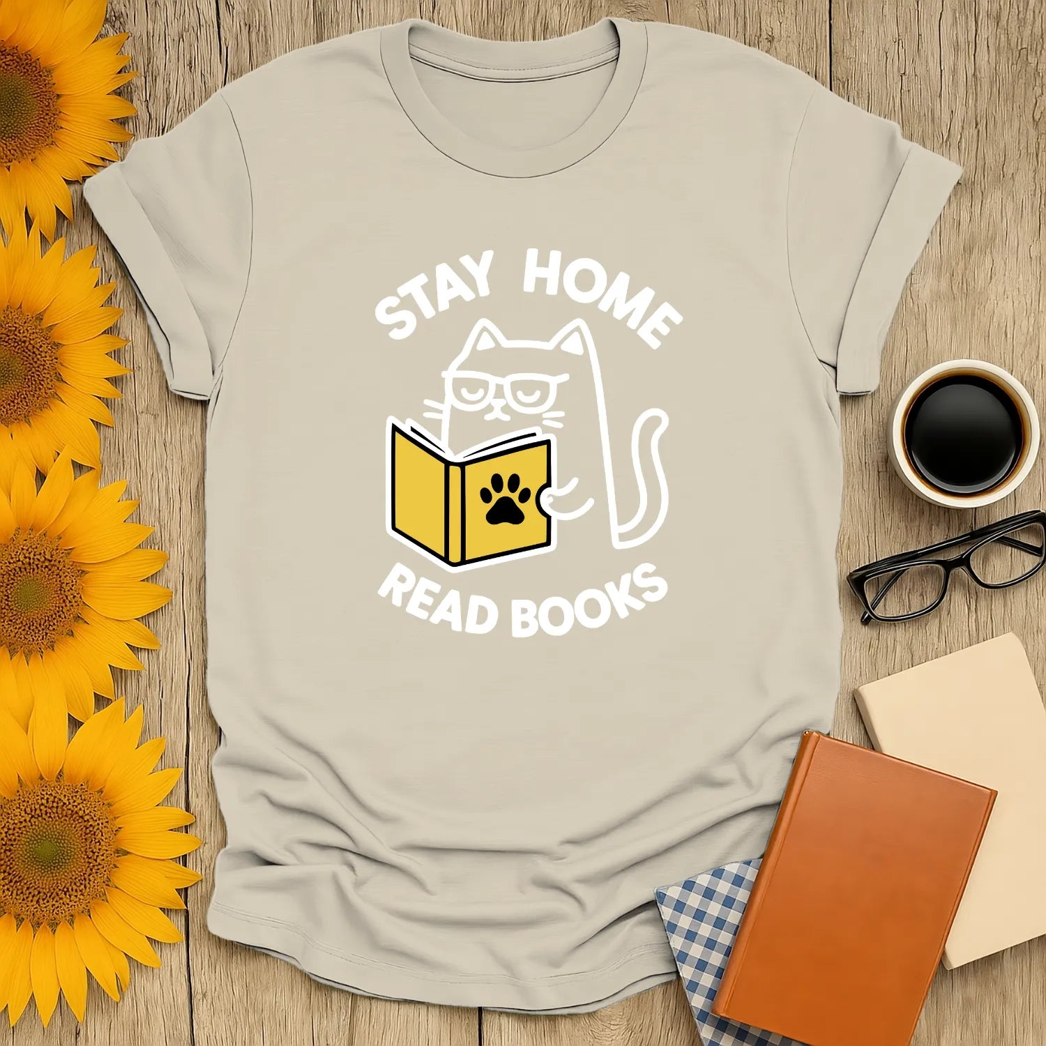 Light gray t-shirt featuring a cat reading a book with text "Stay Home Read Books"—a cozy gift for book lovers.