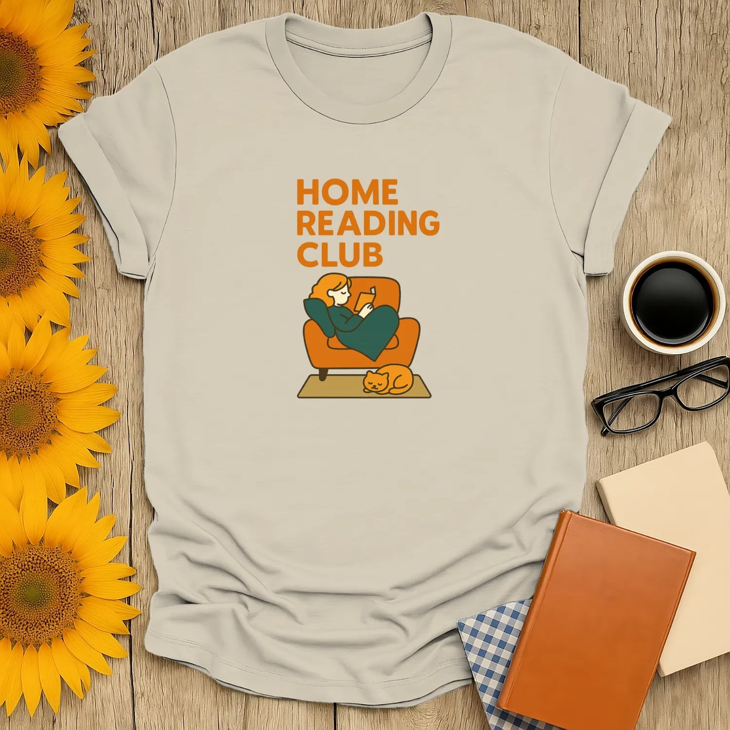 Cozy book lover t-shirt featuring a cat and person reading at home, perfect for gift-giving to readers who enjoy cats and tea.
