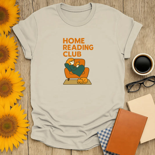 Cozy book lover t-shirt featuring a cat and person reading at home, perfect for gift-giving to readers who enjoy cats and tea.