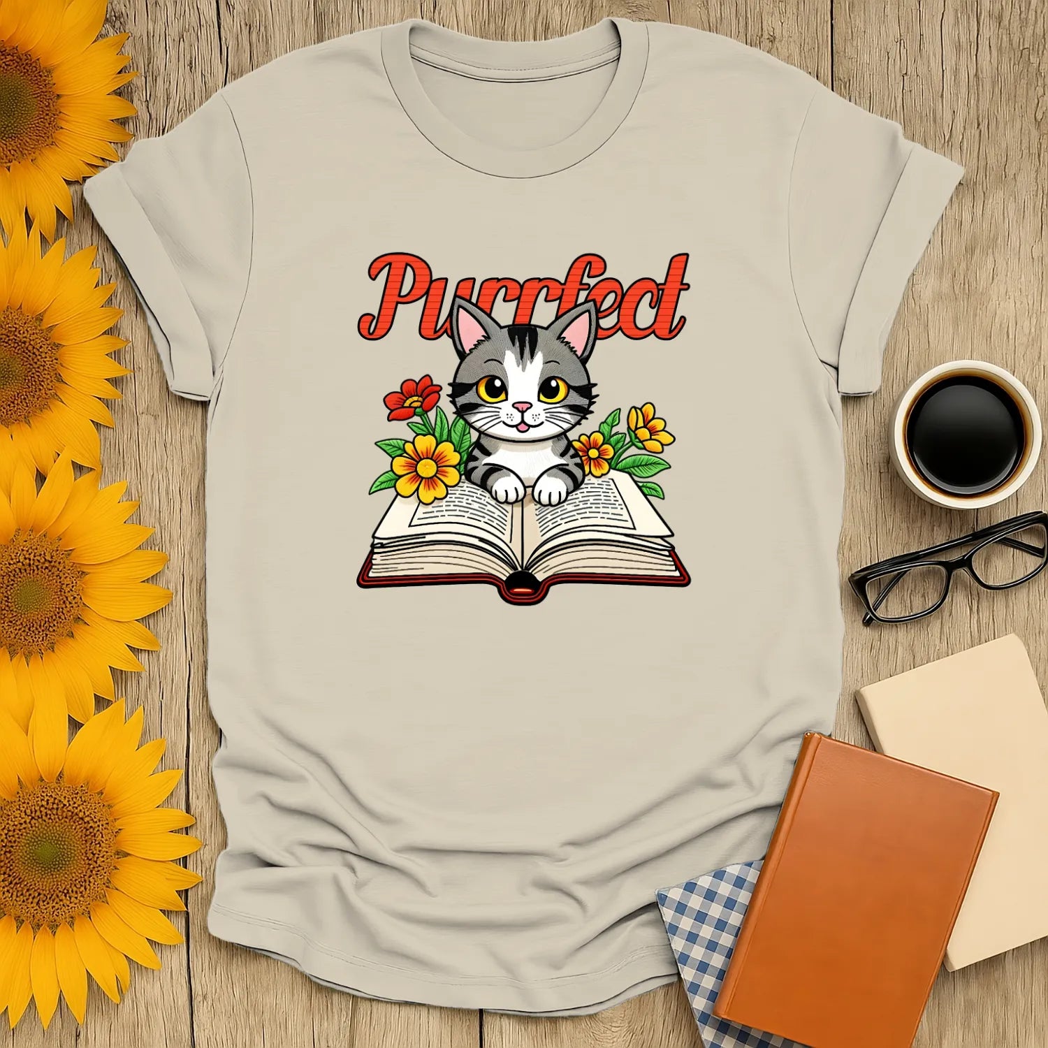 Purrfect Page T-Shirt featuring a cute kitten on a book surrounded by flowers, perfect for book and cat lovers.