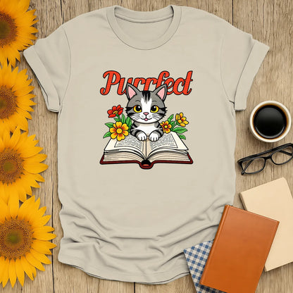 Purrfect Page T-Shirt featuring a cute kitten on a book surrounded by flowers, perfect for book and cat lovers.