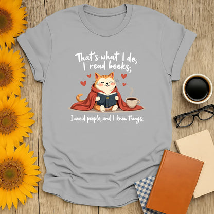 Cozy cat reading a book with coffee, text: 'That's what I do, I read books, I avoid people, and I know things' - perfect gift for book lovers.