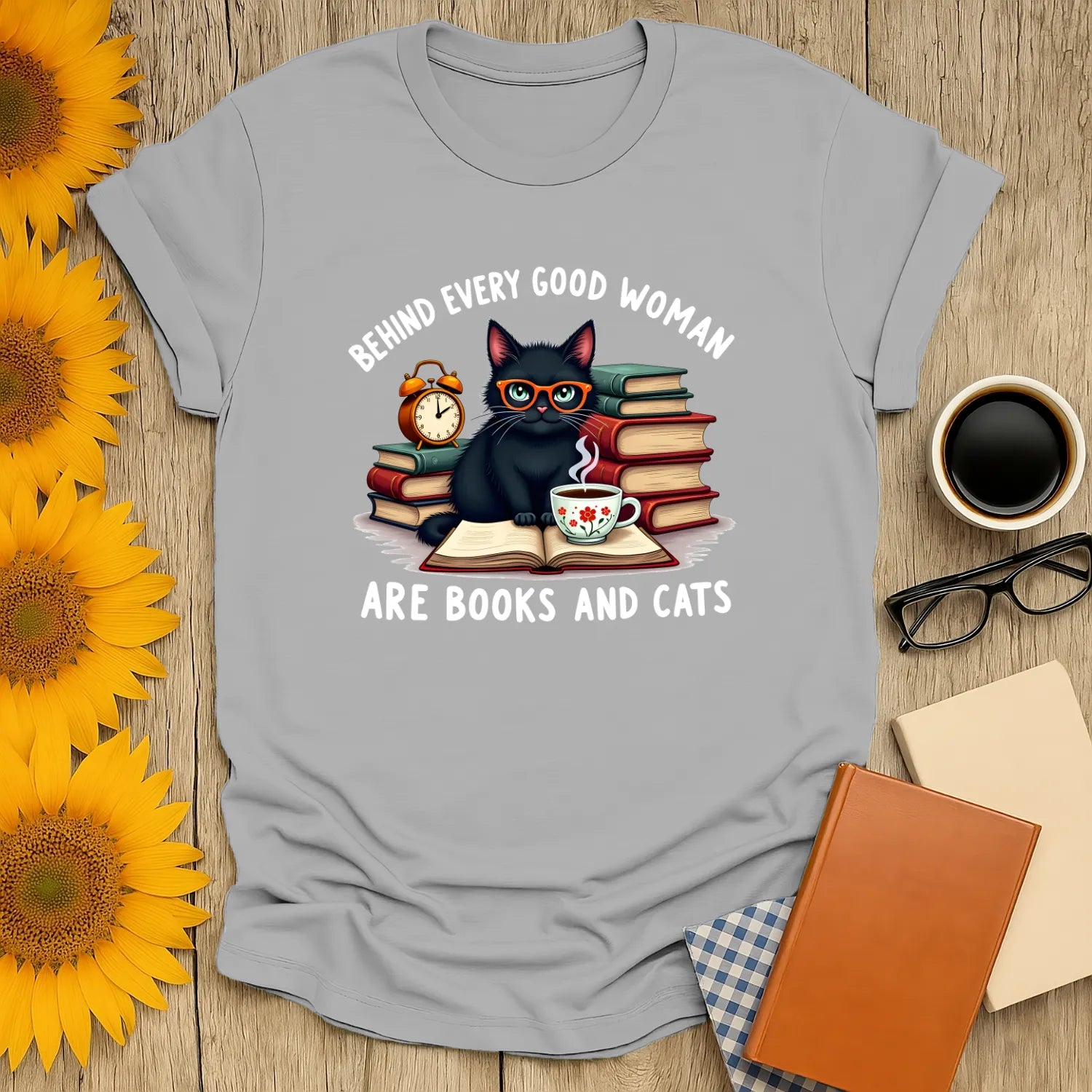 Gray bookworm t-shirt featuring a cute black cat, stacked books, clock, and cup—perfect gift for book lovers and cat enthusiasts.