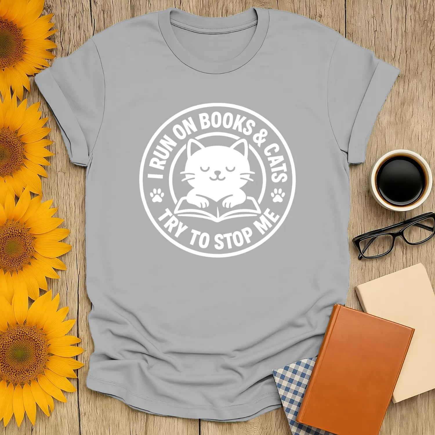 Cozy cat reading shirt with playful text: 'I Run on Books & Cats, Try to Stop Me'—perfect gift for book lovers and cat enthusiasts.