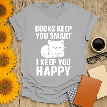 Funny book lover t-shirt featuring a cute cat and text 'Books Keep You Smart, I Keep You Happy', perfect for cozy reading.