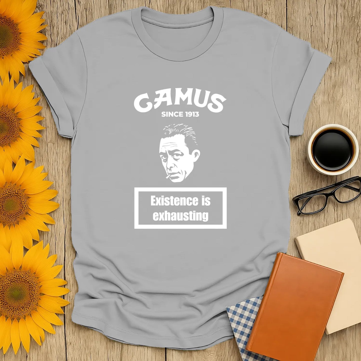 Gray Camus tee with 'Existence is exhausting' text & classic illustration; perfect for book lovers, tea, cats, and cozy reading.