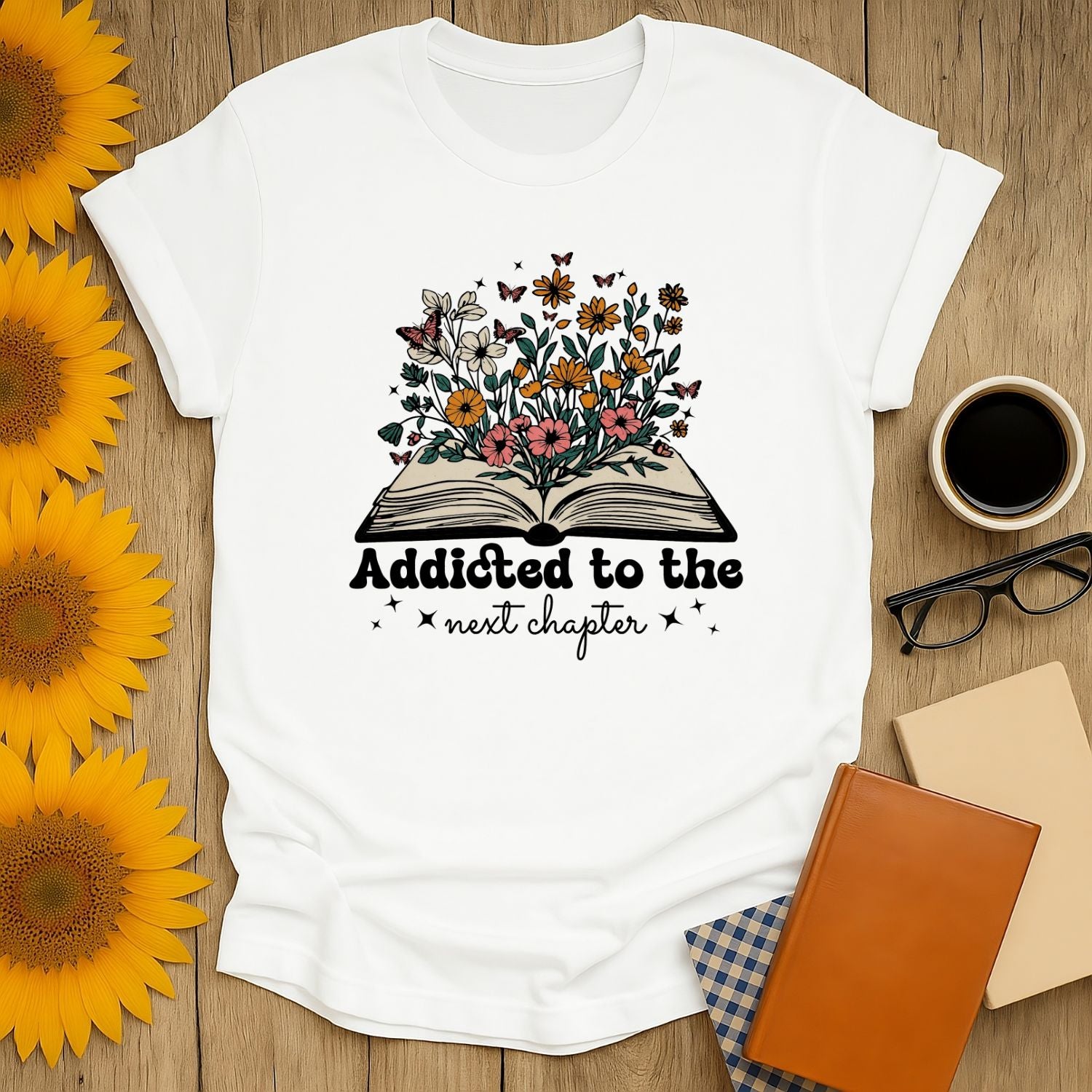 Addicted to the next chapter shirt with flowers & butterflies over an open book—a cozy tee for book lovers.