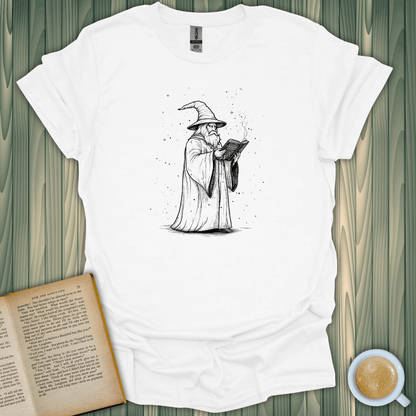 Wizard's Grimoire T-Shirt showcasing a wizard reading from a grimoire, perfect for book lovers, made from 100% cotton.