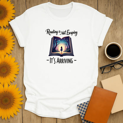 Cozy book lover shirt featuring 'Reading is Not Escaping, It's Arriving' with whimsical illustration; perfect gift for readers.