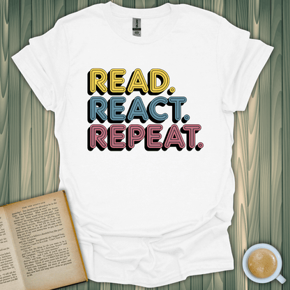 White t-shirt with colorful text 'READ. REACT. REPEAT.' perfect for book lovers. Made of 100% ring-spun cotton.