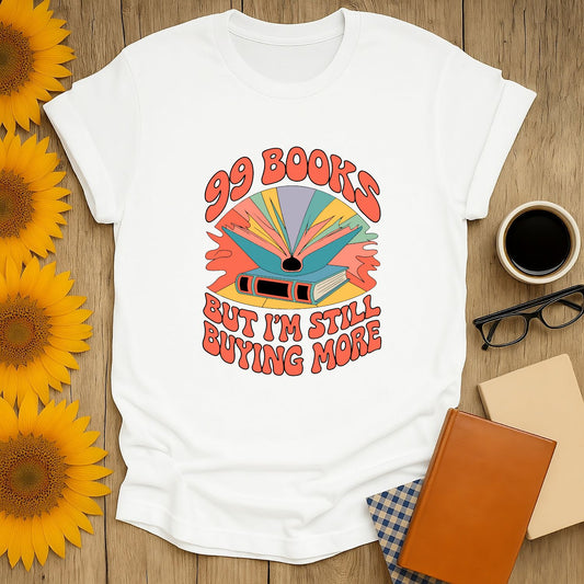 Cozy unisex shirt featuring '99 Books But I'm Still Buying More' design, perfect for book lovers who cherish cats, coffee, & humor.