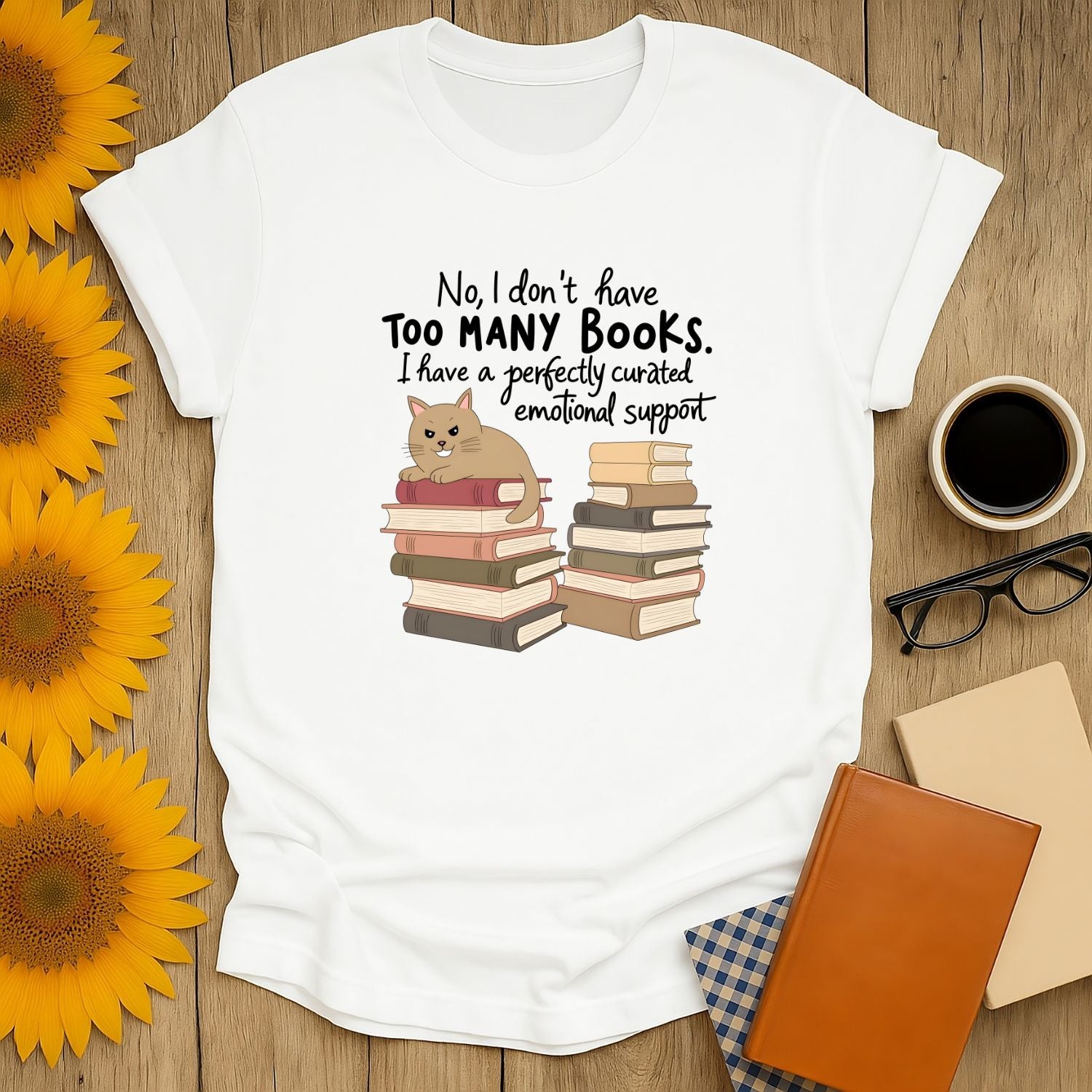 Funny book lover shirt featuring a cat atop stacked books and text, perfect for cozy reading with coffee or tea.
