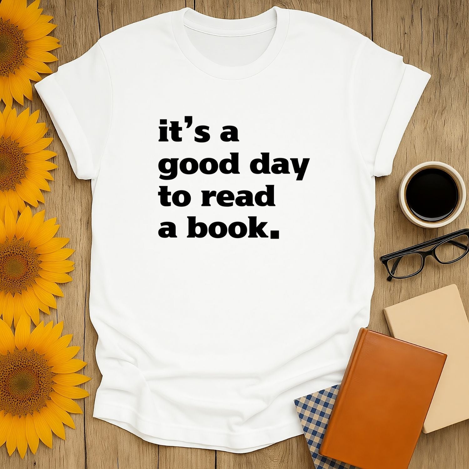 A cozy white tee with bold text: 'it's a good day to read a book.' Perfect for book lovers, coffee fans, and cat enthusiasts.