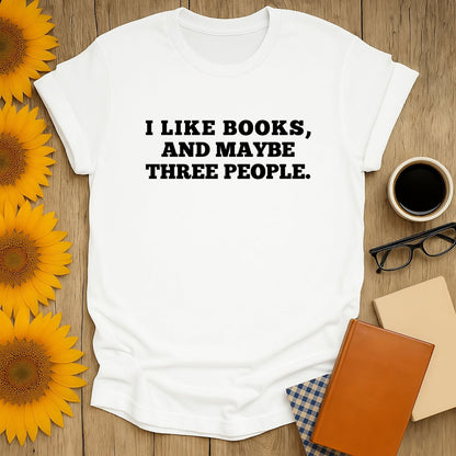 Cozy book lover shirt reads 'I like books, and maybe three people.' Perfect gift for readers who enjoy tea and cats.