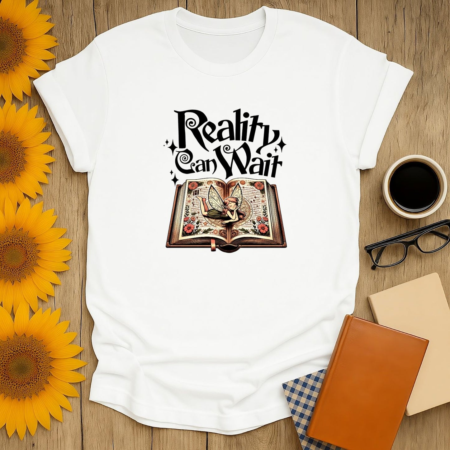 Funny reading tee featuring a whimsical book illustration with "Reality Can Wait" text, perfect for cat and coffee lovers.