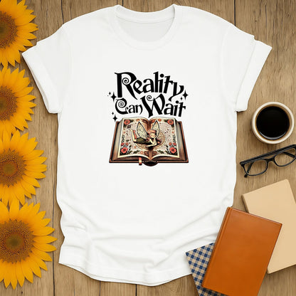 Funny reading tee featuring a whimsical book illustration with "Reality Can Wait" text, perfect for cat and coffee lovers.