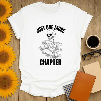 Skeleton reading a book with coffee, saying 'Just One More Chapter' – perfect cozy book shirt for cat-loving readers!